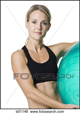 Portrait of a young woman holding an exercise ball View Large Photo Image Stock Photograph - Portrait of a young woman holding an exercise ball. Fotosearch