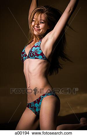 Portrait of a young woman in a bikini, smiling and jumping View Large Photo Image Picture - Portrait of a young woman in a bikini, smiling and jumping. Fotosearch