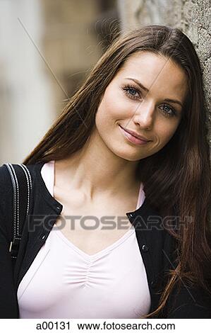 Portrait of a young woman leaning on a wall View Large Photo Image Stock Image - Portrait of a young woman leaning on a wall. Fotosearch