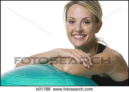 Portrait of a young woman leaning on a fitness ball View Large Photo Image Stock Photo - Portrait of a young woman leaning on a fitness ball. Fotosearch