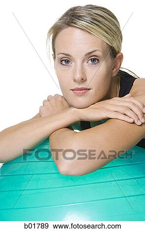 Portrait of a young woman leaning on a fitness ball View Large Photo Image Stock Photo - Portrait of a young woman leaning on a fitness ball. Fotosearch