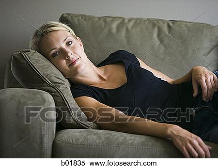 Portrait of a young woman lying down on a couch View Large Photo Image Stock Photography - Portrait of a young woman lying down on a couch. Fotosearch