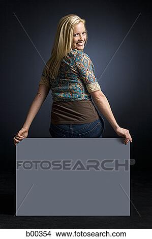 Portrait of a young woman sitting on a blank sign View Large Photo Image Picture - Portrait of a young woman sitting on a blank sign. Fotosearch
