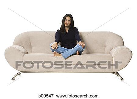 Portrait of a young woman sitting on a couch View Large Photo Image Stock Photo - Portrait of a young woman sitting on a couch. Fotosearch