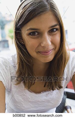 Portrait of a young woman sitting outdoors View Large Photo Image Stock Image - Portrait of a young woman sitting outdoors. Fotosearch