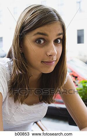Portrait of a young woman sitting outdoors View Large Photo Image Stock Image - Portrait of a young woman sitting outdoors. Fotosearch