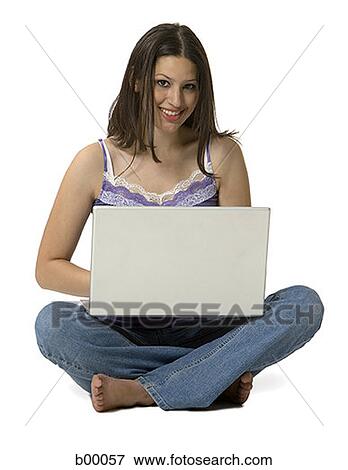 Stock Photo - Portrait of a young woman smiling and working on a laptop. Fotosearch