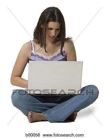 Stock Photograph - Portrait of a young woman smiling and working on a laptop. Fotosearch