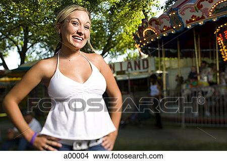 Picture - Portrait of a young woman smiling at a carnival. Fotosearch