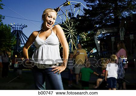 Portrait of a young woman smiling in an amusement park View Large Photo Image Stock Photo - Portrait of a young woman smiling in an amusement park. Fotosearch