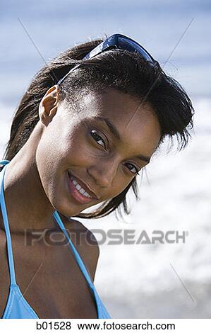 Portrait of a young woman smiling on the beach View Large Photo Image Stock Photo - Portrait of a young woman smiling on the beach. Fotosearch