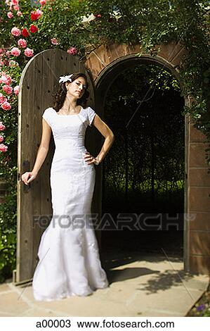 Portrait of a young woman standing at the doorway View Large Photo Image Stock Image - Portrait of a young woman standing at the doorway. Fotosearch