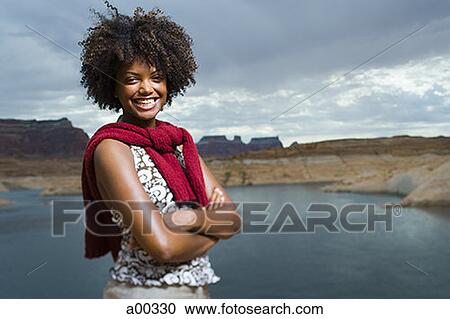 Portrait of a young woman standing on a lakeside View Large Photo Image Stock Image - Portrait of a young woman standing on a lakeside. Fotosearch
