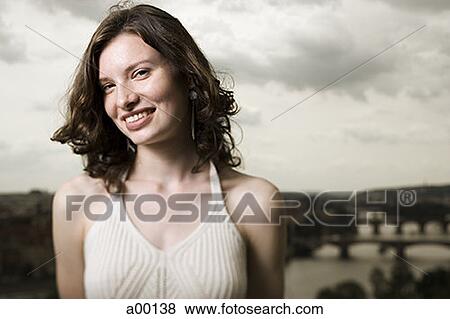 Stock Photo - Portrait of a young woman standing outdoors. Fotosearch