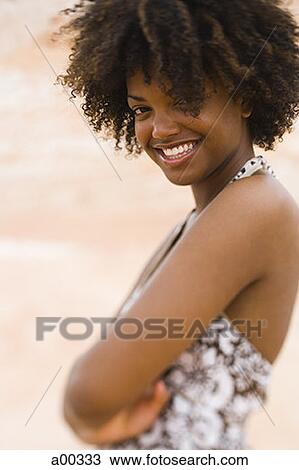 Portrait of a young woman standing with her arms crossed View Large Photo Image Stock Image - Portrait of a young woman standing with her arms crossed. Fotosearch