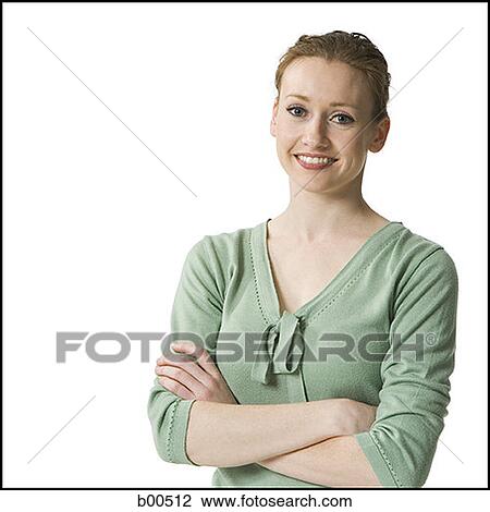 Stock Image - Portrait of a young woman standing with her arms folded. Fotosearch