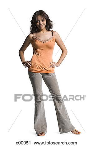 Stock Image - Portrait of a young woman standing with hands on hips. Fotosearch