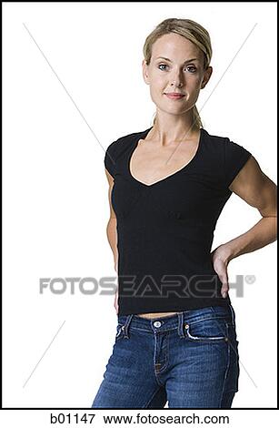 Portrait of a young woman standing with her hands behind her back View Large Photo Image Stock Photo - Portrait of a young woman standing with her hands behind her back. Fotosearch