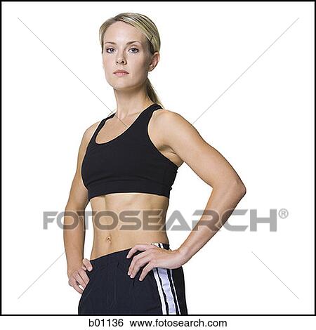 Portrait of a young woman standing with her hands on hips View Large Photo Image Stock Photograph - Portrait of a young woman standing with her hands on hips. Fotosearch