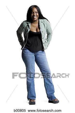 Stock Photography - Portrait of a young woman standing with her hands behind her back. Fotosearch