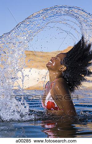 Portrait of a young woman tossing her wet hair in a lake View Large Photo Image Stock Photography - Portrait of a young woman tossing her wet hair in a lake. Fotosearch