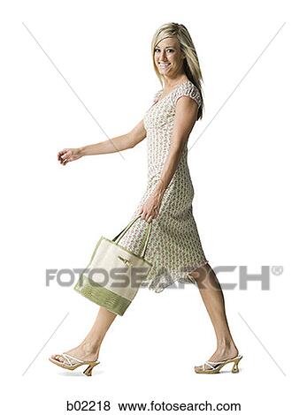 Portrait of a young woman walking with a purse View Large Photo Image Stock Photo - Portrait of a young woman walking with a purse. Fotosearch