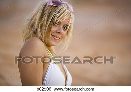 Stock Photograph - Portrait of a young woman wearing sunglasses on her head. Fotosearch