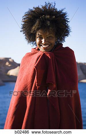 Stock Photograph - Portrait of a young woman wrapped in a blanket. Fotosearch
