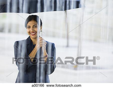 Portrait of an adult woman standing with an umbrella in the rain View Large Photo Image Stock Photograph - Portrait of an adult woman standing with an umbrella in the rain. Fotosearch