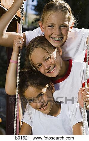 Portrait of three girls sitting on a swing View Large Photo Image Stock Image - Portrait of three girls sitting on a swing. Fotosearch