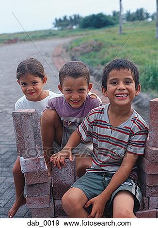 Portrait of two boys and a girl sitting on bricks View Large Photo Image Stock Photo - Portrait of two boys and a girl sitting on bricks. Fotosearch