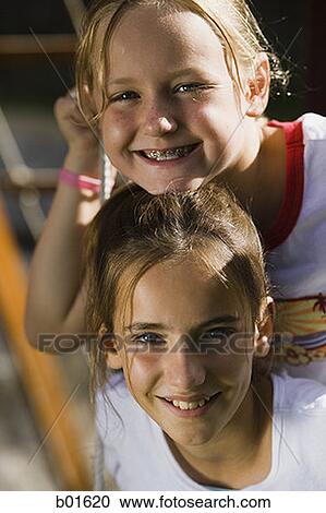 Portrait of two girls sitting on a swing View Large Photo Image Stock Image - Portrait of two girls sitting on a swing. Fotosearch