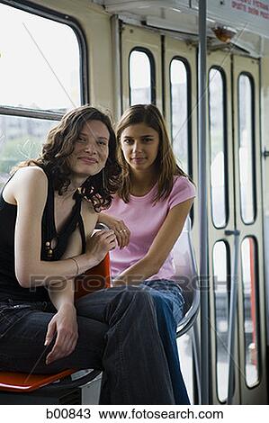 Portrait of two teenage girls sitting inside a bus View Large Photo Image Stock Image - Portrait of two teenage girls sitting inside a bus. Fotosearch