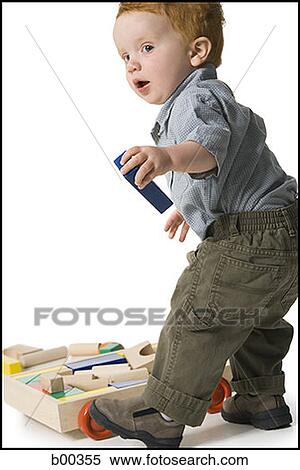 Profile of a baby boy playing with toys View Large Photo Image Stock Photography - Profile of a baby boy playing with toys. Fotosearch