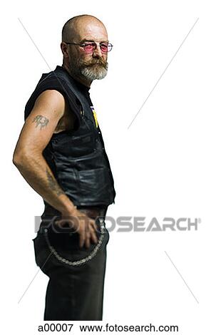 Profile of a mature biker standing with his hand on his hips View Large Photo Image Stock Photo - Profile of a mature biker standing with his hand on his hips. Fotosearch