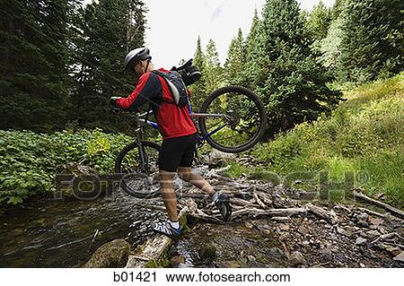 Profile of a mature man carrying a bicycle over a creek View Large Photo Image Stock Image - Profile of a mature man carrying a bicycle over a creek. Fotosearch