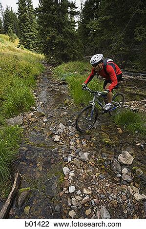 Profile of a mature man cycling over a creek View Large Photo Image Stock Image - Profile of a mature man cycling over a creek. Fotosearch
