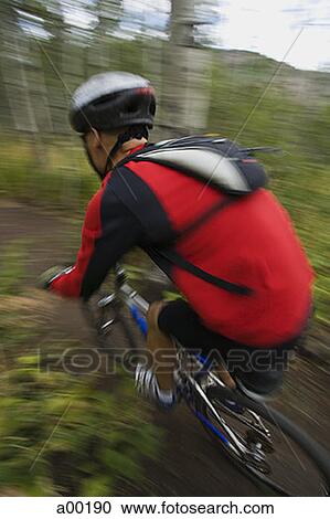 Stock Image - Profile of a mature man mountain biking. Fotosearch