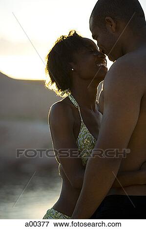 Profile of a young couple hugging View Large Photo Image Stock Photo - Profile of a young couple hugging. Fotosearch