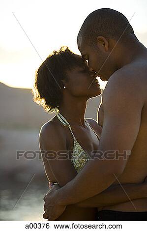 Stock Photograph - Profile of a young couple hugging. Fotosearch