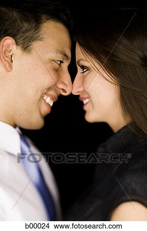 Profile of a young couple standing face to face View Large Photo Image Picture - Profile of a young couple standing face to face. Fotosearch