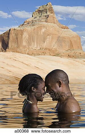 Profile of a young couple standing in a lake View Large Photo Image Stock Photo - Profile of a young couple standing in a lake. Fotosearch