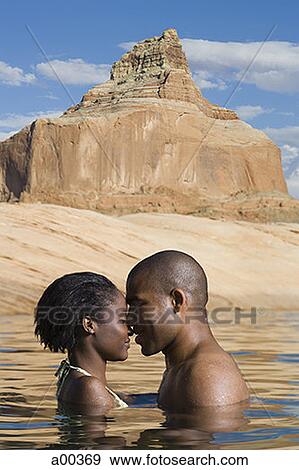 Stock Photo - Profile of a young couple standing in a lake. Fotosearch