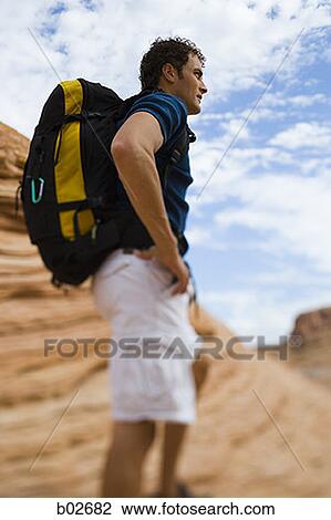 Profile of a young man carrying a backpack View Large Photo Image Stock Image - Profile of a young man carrying a backpack. Fotosearch