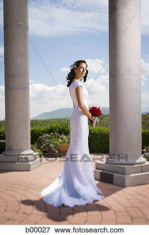 Stock Photo - Profile of a young modern bride holding a bunch of flowers. Fotosearch