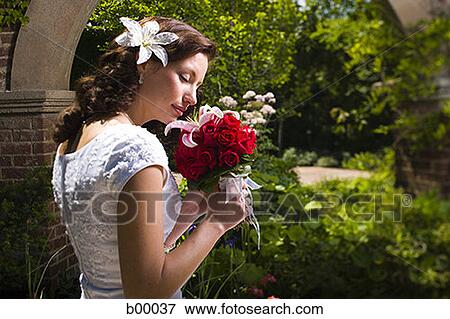 Stock Photo - Profile of a young modern bride smelling flowers. Fotosearch