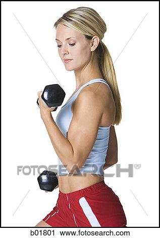 Profile of a young woman exercising with dumbbells View Large Photo Image Stock Image - Profile of a young woman exercising with dumbbells. Fotosearch