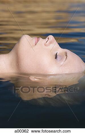 Profile of a young woman floating in water View Large Photo Image Stock Image - Profile of a young woman floating in water. Fotosearch