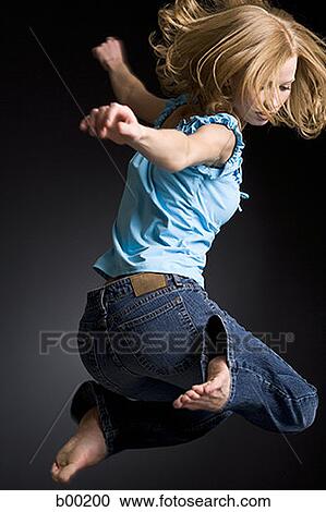 Stock Image - Profile of a young woman jumping. Fotosearch
