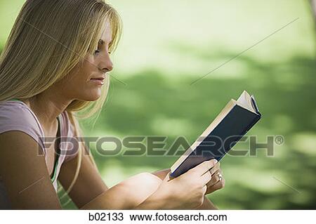 Profile of a young woman reading a book in a park View Large Photo Image Stock Image - Profile of a young woman reading a book in a park. Fotosearch